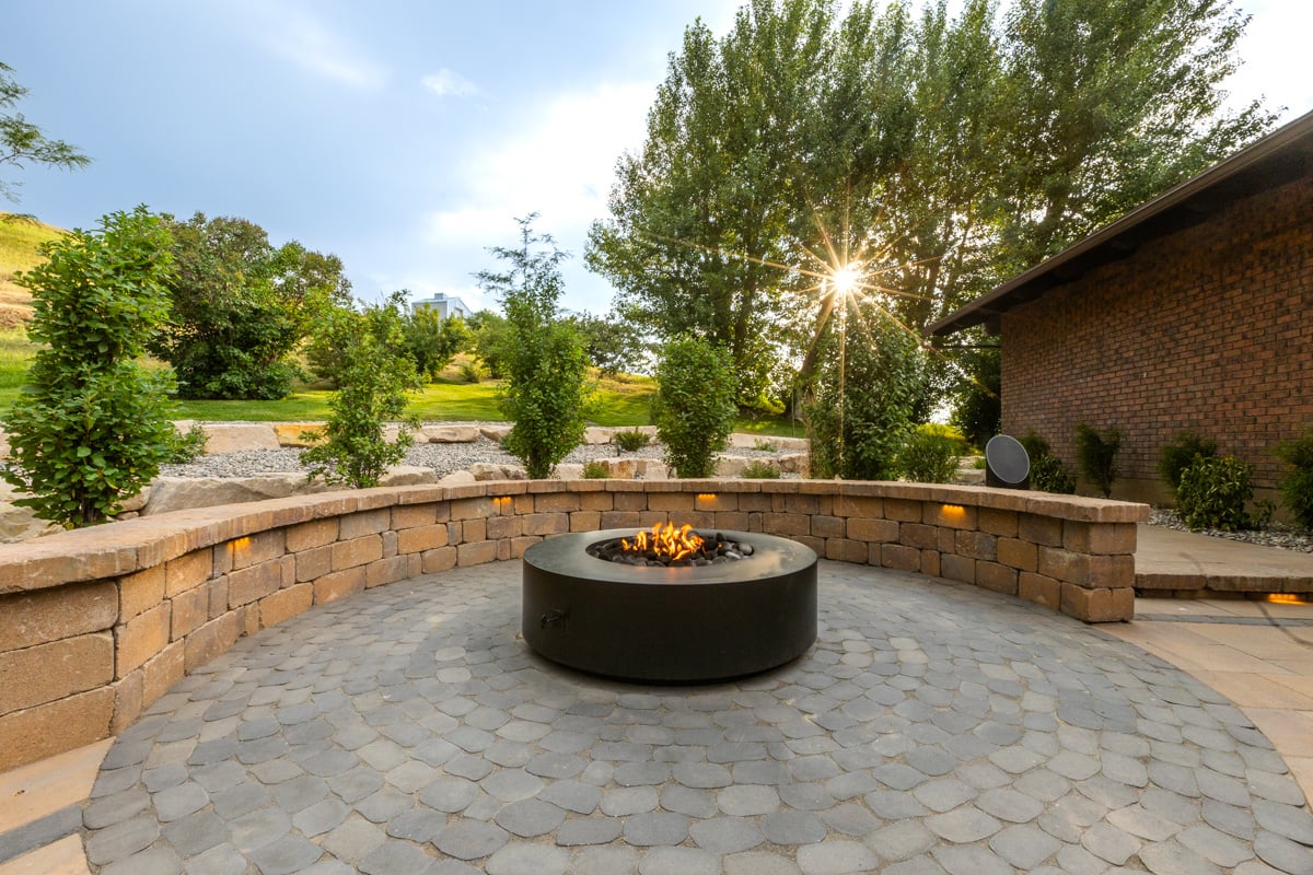 firepit patio pavers home trees landscape gathering space lighting