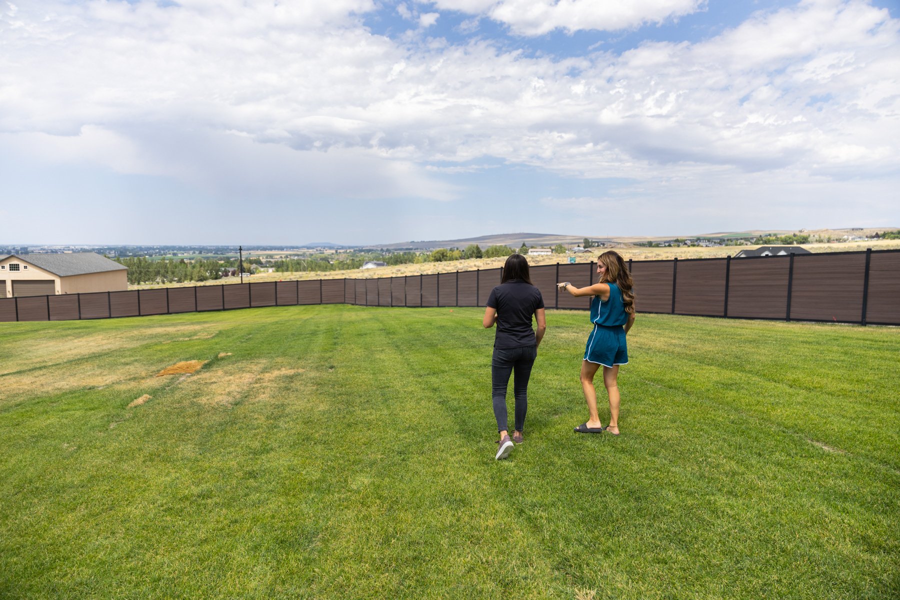 landscape design customer consultation walking spacious backyard lawn fence