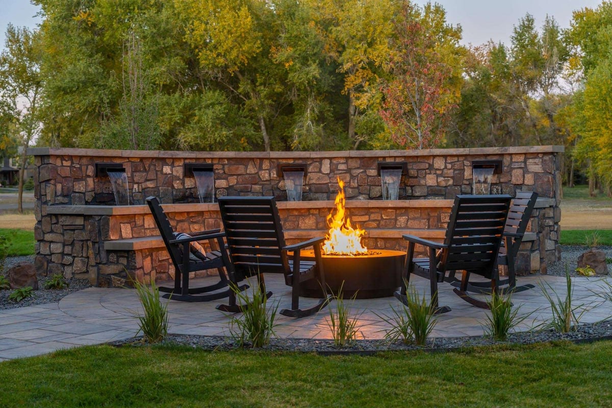 firepit with stone water feature and rocking chairs