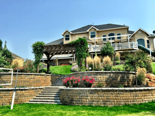 Landscape design with retaining walls, plants, and pergola