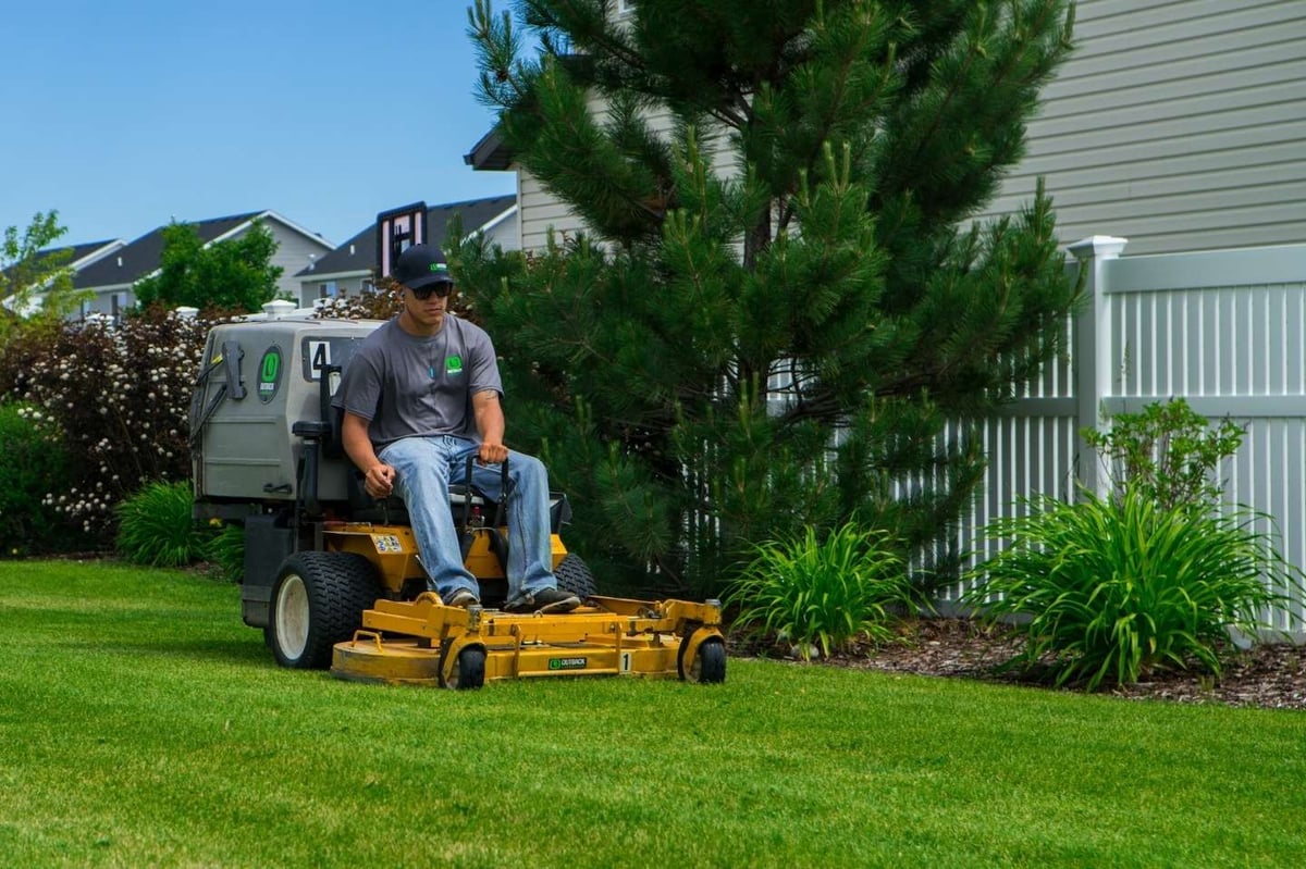 landscape maintenance team mows grass