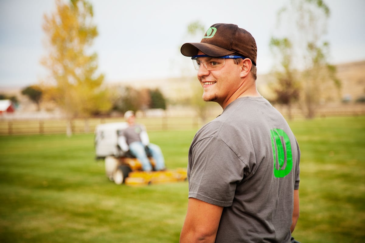 lawn care team mows grass
