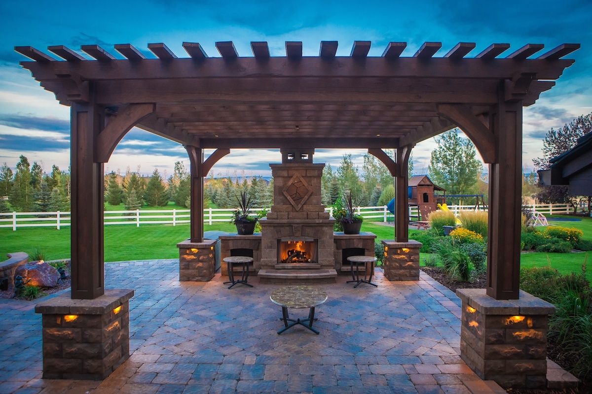 paver patio under pergola with outdoor fireplace