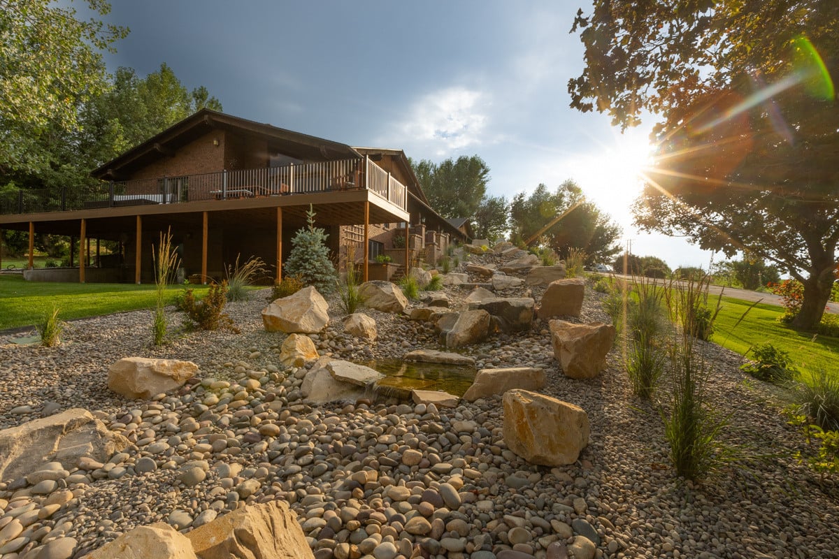 deck patio gravel plants steps lighting boulders water feature stream waterfall stone pool grass home