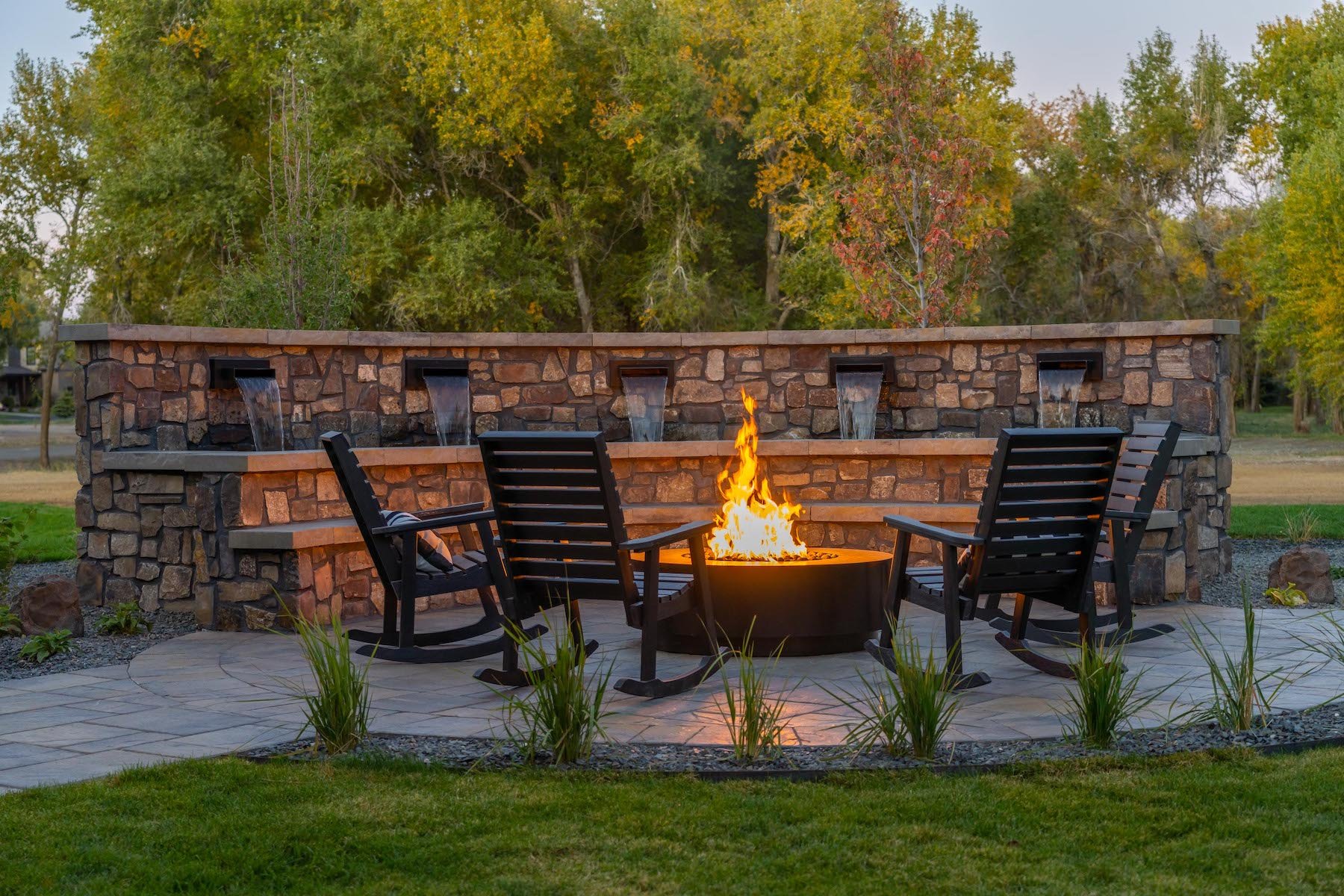 fire pit surrounded by chairs and water feature