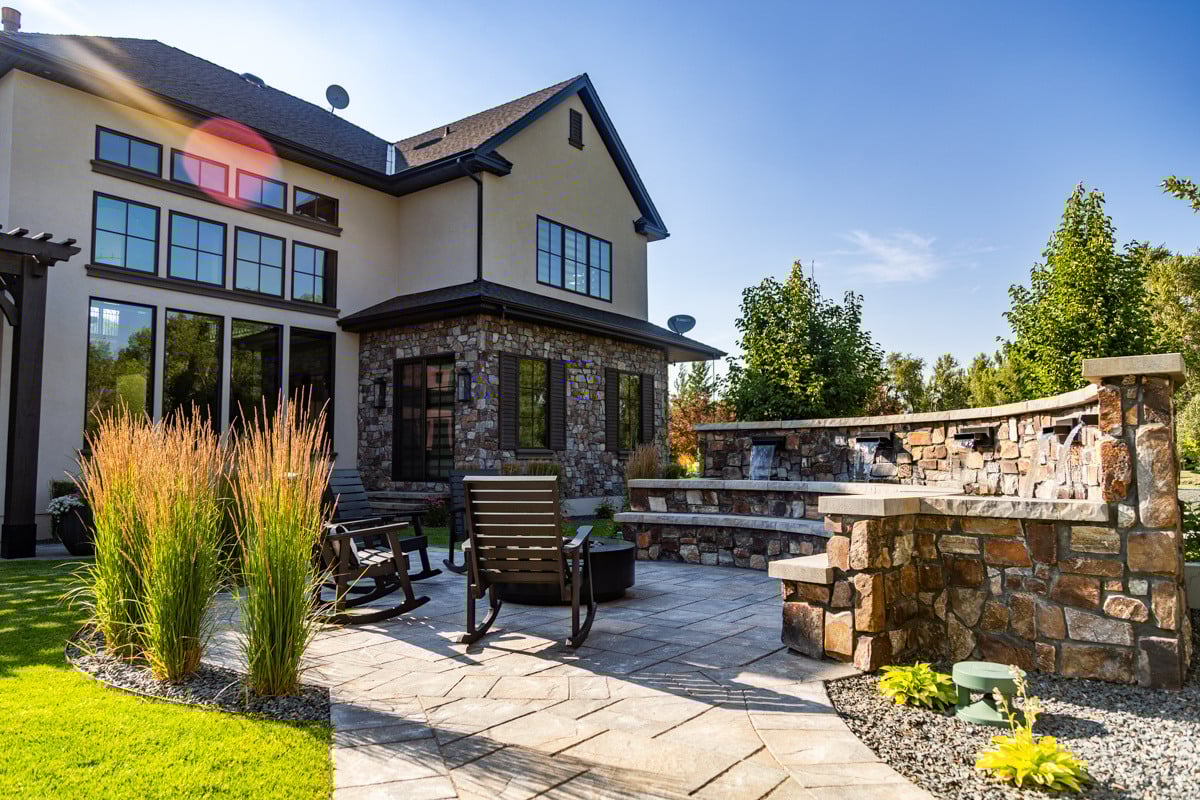 patio firepit chairs seating plants grass turf green lawn water feature waterfall home house gravel wall 2