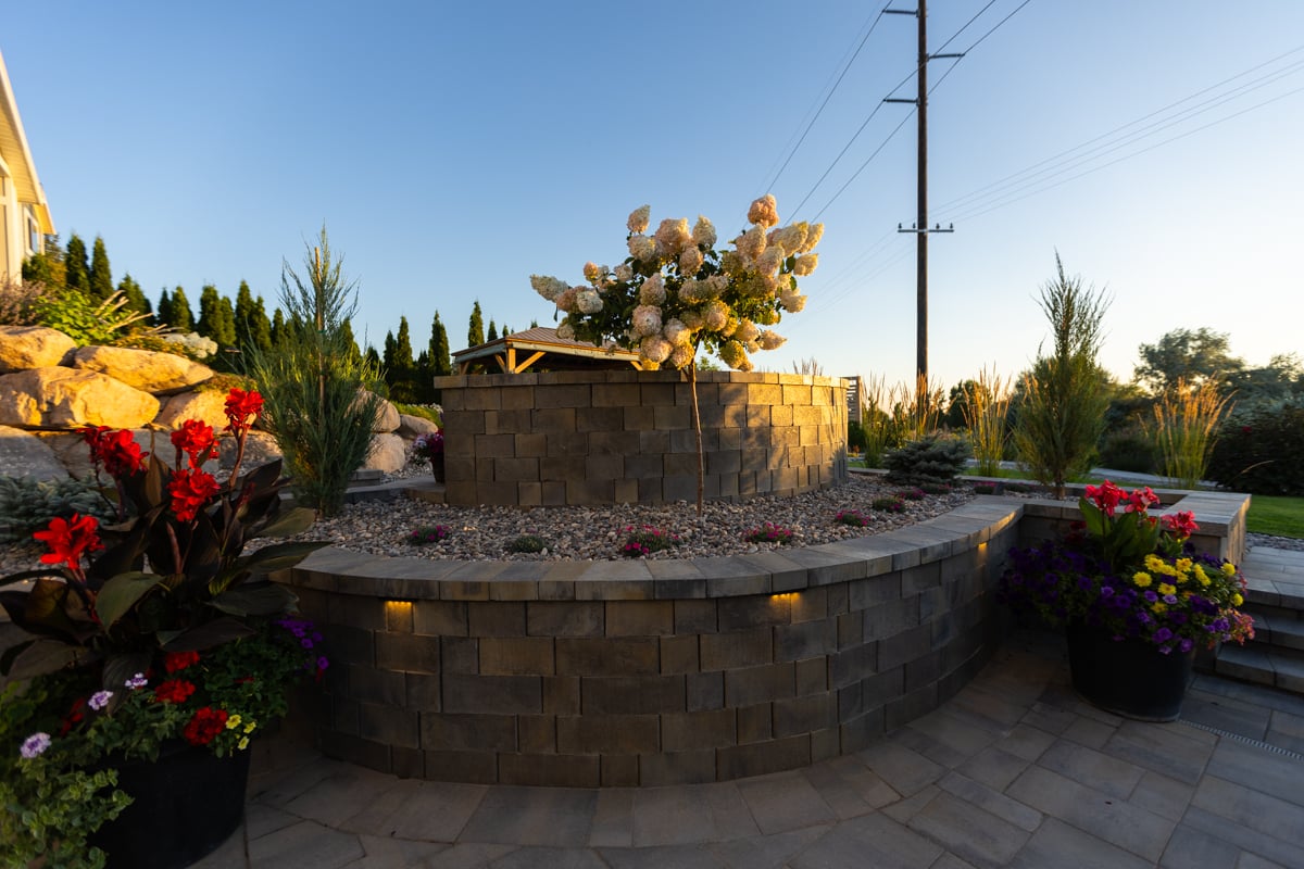 retaining wall landscape lighting paver patio plants container plantings gravel bed