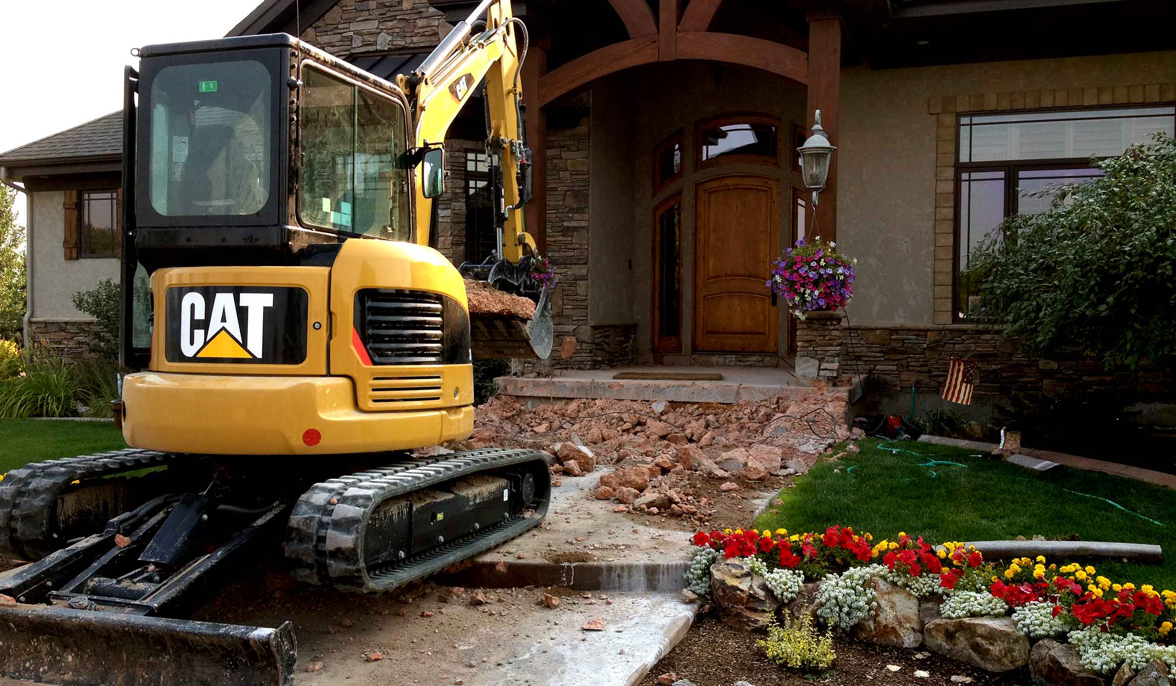 front loader excavates old paver patio material