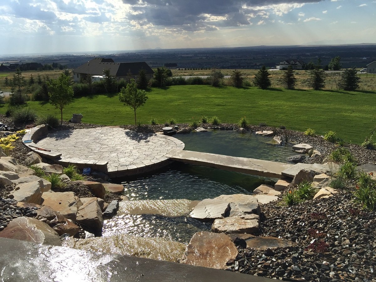 large water feature with waterfall and flagstone patio