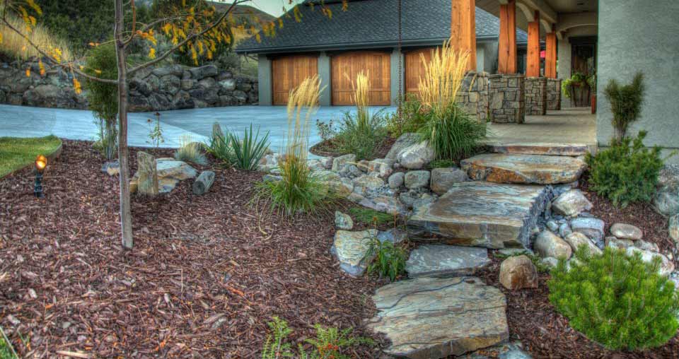 plantings and stone with mulch near entrance of home