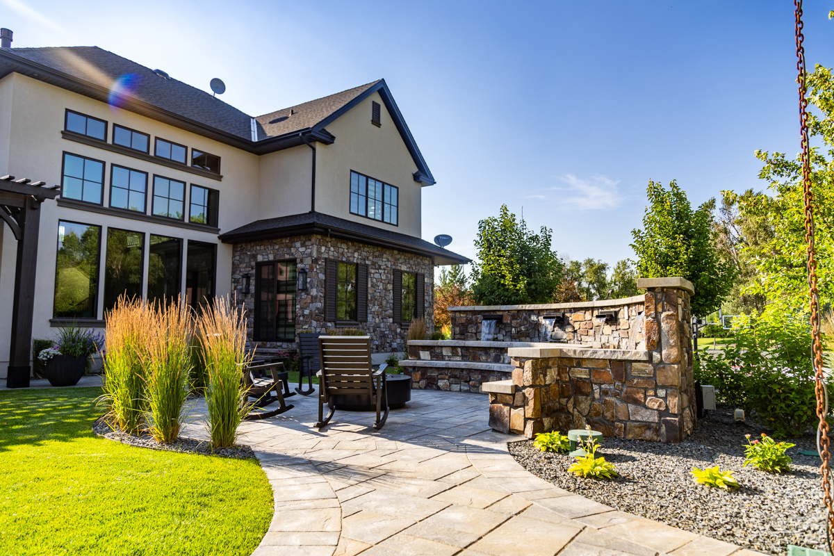 patio firepit chairs seating plants grass turf green lawn water feature waterfall home house gravel wall 3