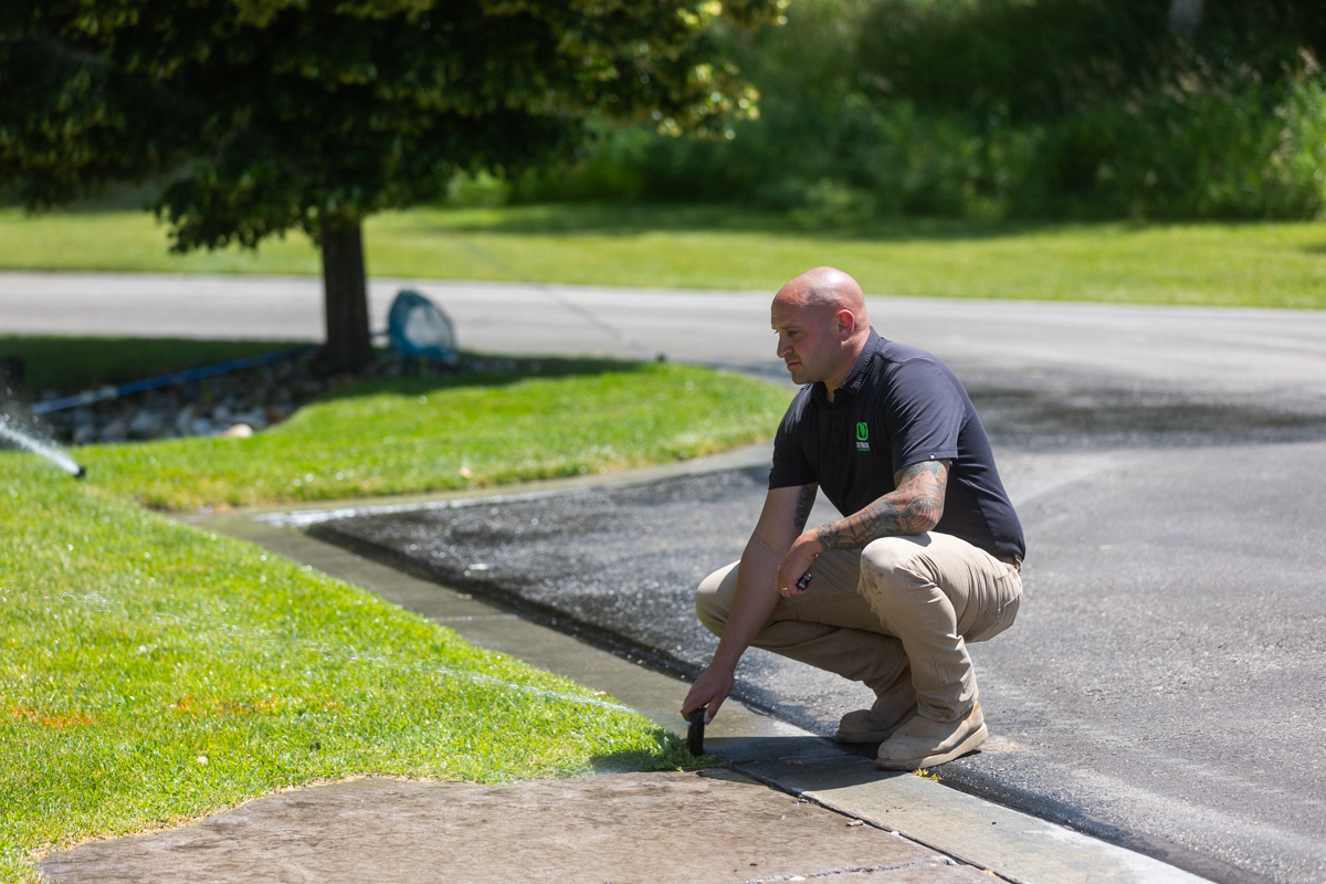 irrigation specialist calibrating a sprinkler system in an idaho falls landscape