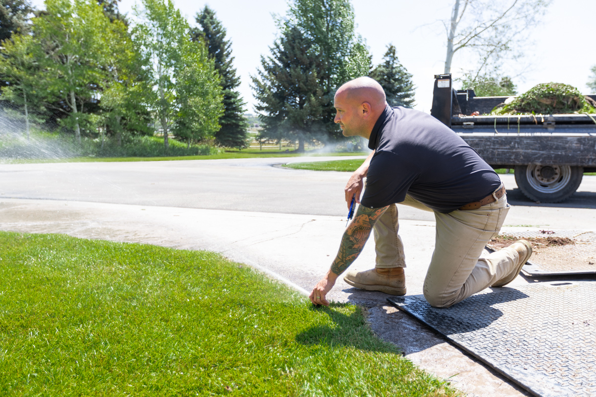 landscape technician calibrating a lawn sprinkler system