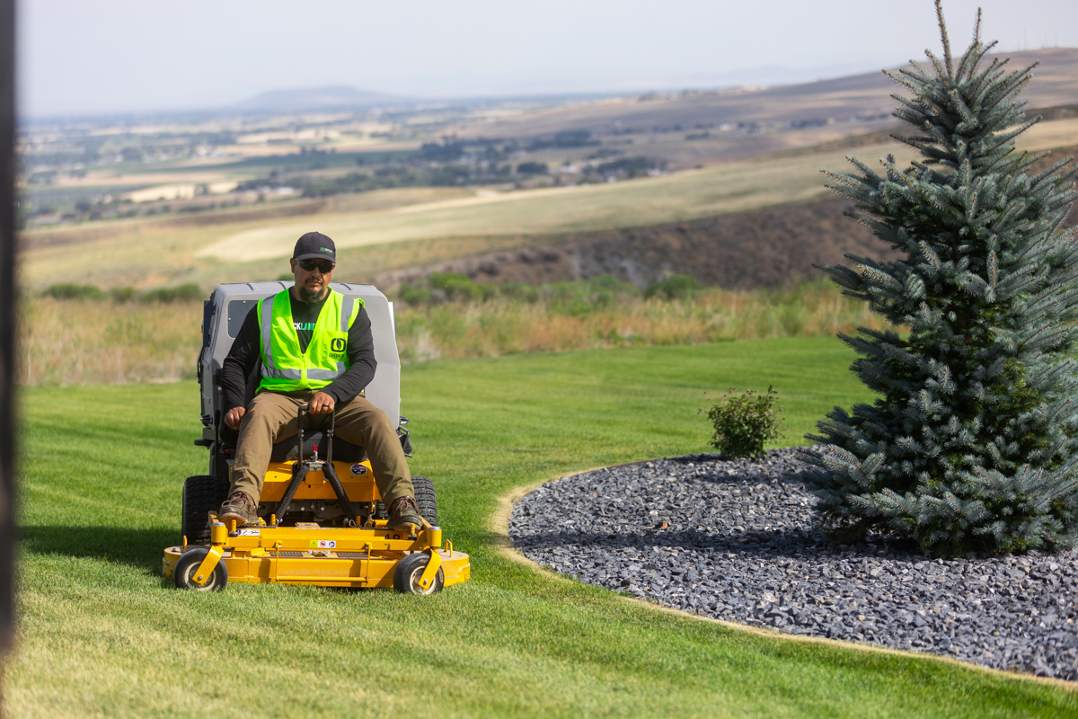 landscape maintenance team mowing a large HOA lawn space in idaho falls